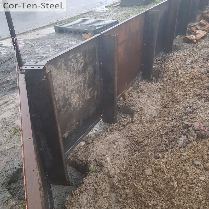 corten steel angle posts set in concrete pile holes
